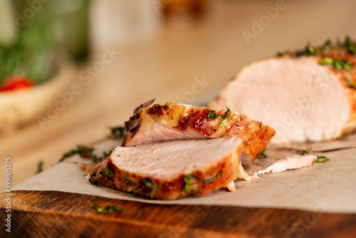 Fotografija Baked in oven with aromatic herbs juicy pork tenderloin fillet cut into thin sli