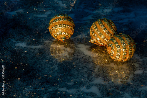 Golden balls on ice. Merry Christmas and happy New year. Christmas background with Christmas decorations. Christmas card. 