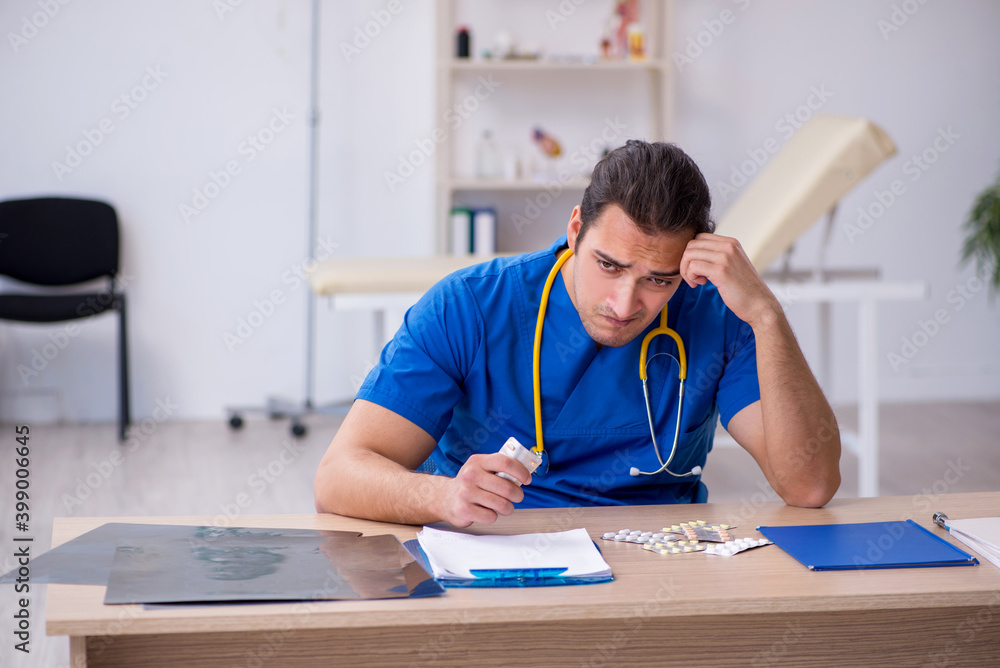 Young male sick doctor being unhappy after night shift Young male sick doctor being unhappy after night shift