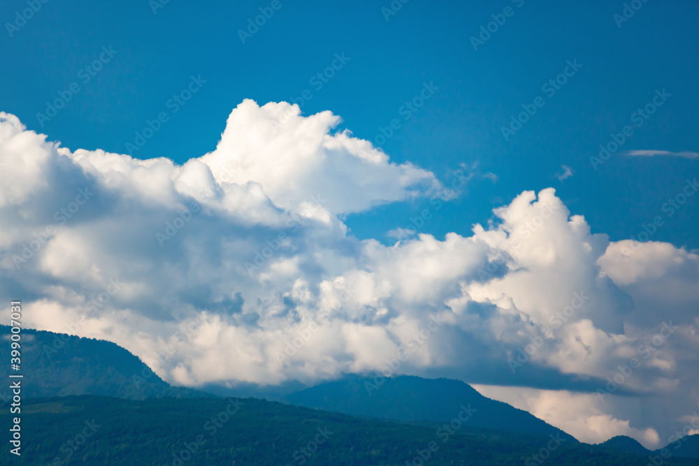 Obraz premium White clouds in blue sky wrapped up mountain peaks with blurry background, used as a background or texture, soft focus