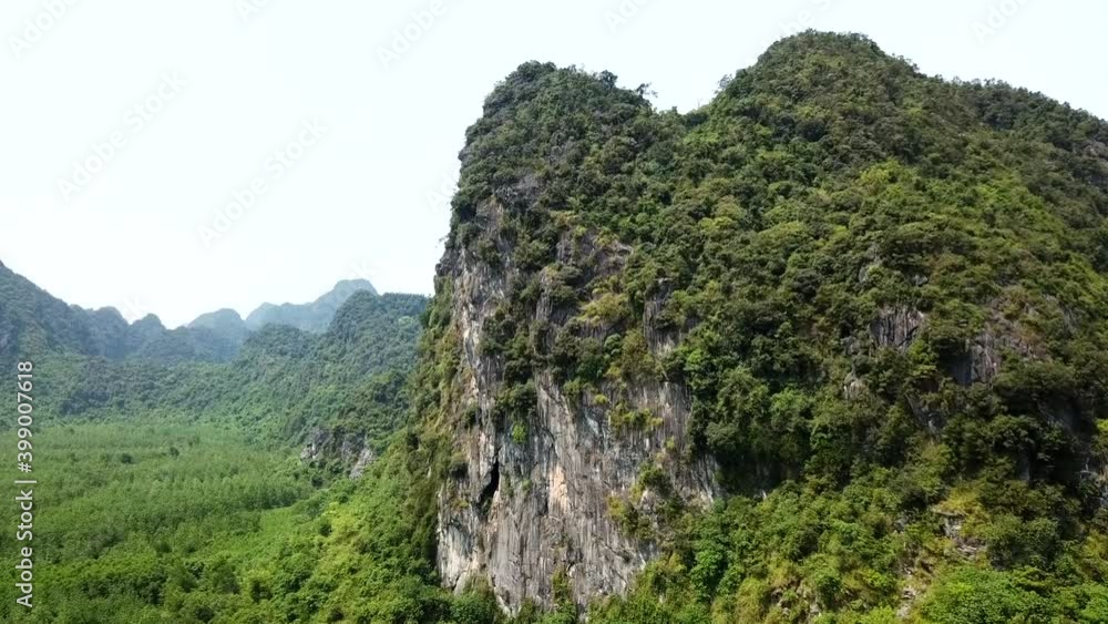 Drone shot of limestone mountain in Quang Binh Province near Dong Hoi, Vietnam, Southeast Asia with mountains in the background. Scene of remote, unpopulated Vietnam scenery. Drone shot of limestone mountain in Quang Binh Province near Dong Hoi, Vietnam, Southeast Asia with mountains in the background. Scene of remote, unpopulated Vietnam scenery.
