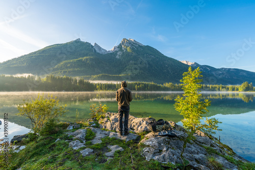 Man overlooking hintersee lake at sunrise. Bavarian Alps on the Austrian border, Germany, Europe photo