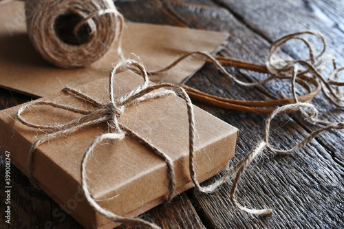 A close up image of a vintage style  brown paper bag and box tied with burlap thread. 