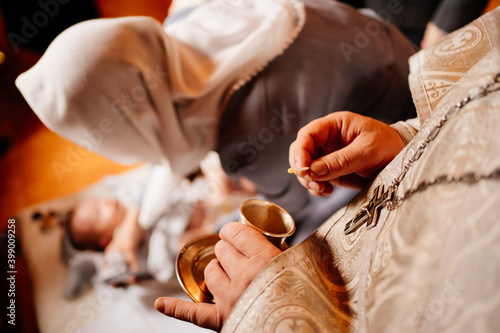 oil for the anointing at the baptism in the hands of the priest.  photo