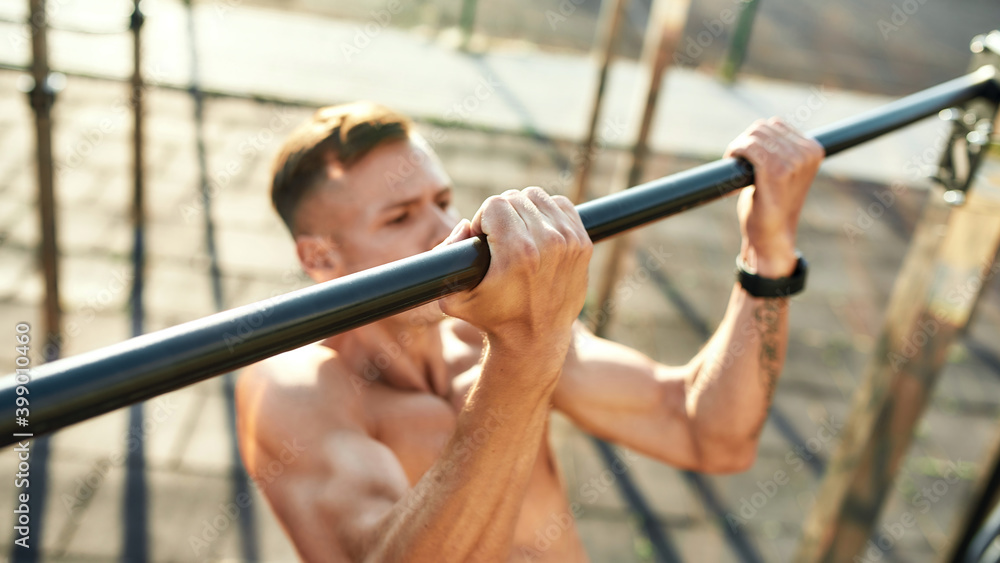 Naklejka premium Selective view on young man hands during pulling up