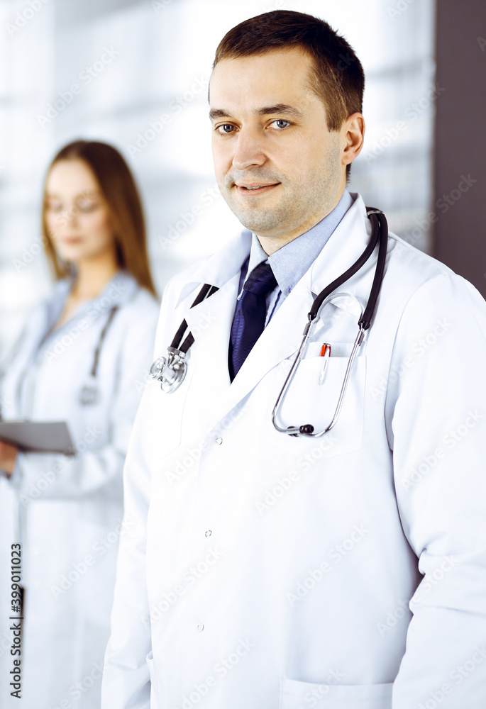 Professional middle aged doctor with a stethoscope at work with colleagues in a clinic. Perfect medical service in a hospital. Medicine and healthcare concept Professional middle aged doctor with a stethoscope at work with colleagues in a clinic. Perfect medical service in a hospital. Medicine and healthcare concept