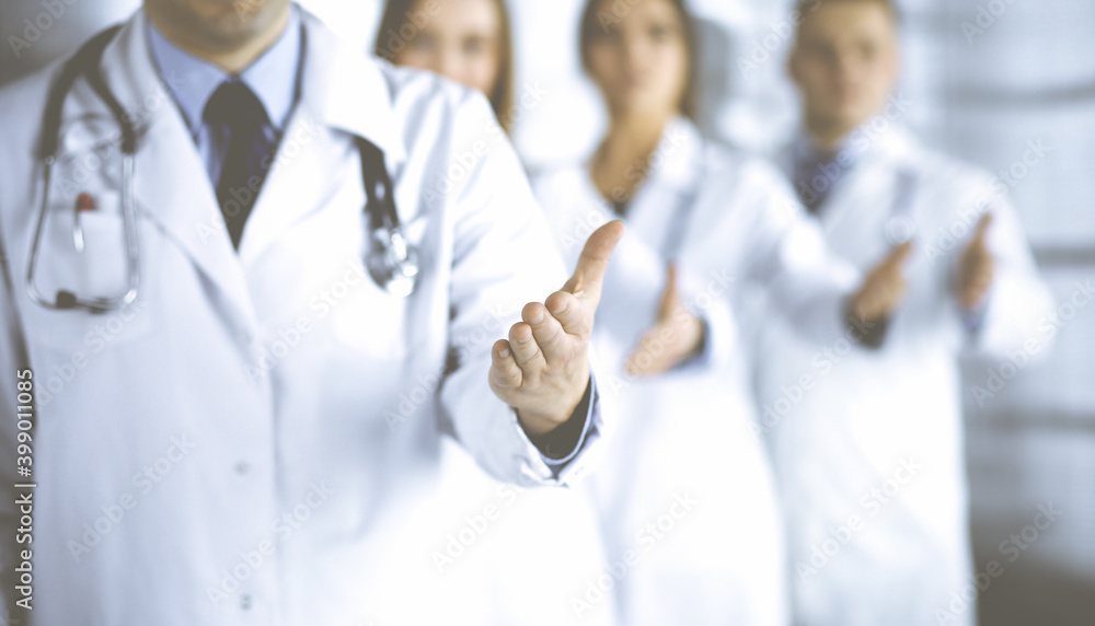 Team of unknown doctors is offering helping hand to the patients, close up. Physicians ready to help people. Medical help, insurance in health care, medicine concept Team of unknown doctors is offering helping hand to the patients, close up. Physicians ready to help people. Medical help, insurance in health care, medicine concept