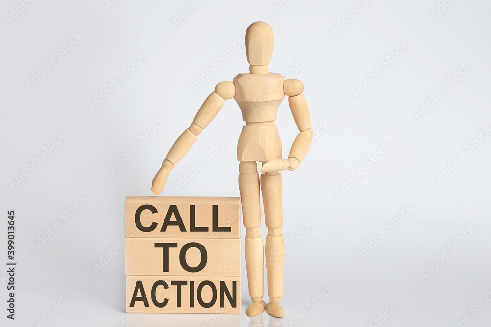 Wooden man shows with a hand text CALL TO ACTION concept on the wooden block Wooden man shows with a hand text CALL TO ACTION concept on the wooden block