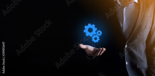Business man in suit holding metal gears and cogwheels mechanism representing interaction teamwork concept,hand hold group of virtual cog gears wheel