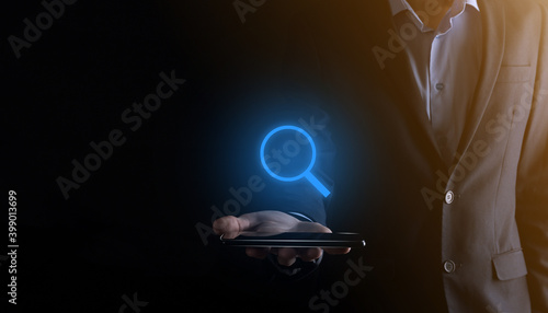 Businessman, man hold in hand magnifying glass icon.business, technology and internet concept