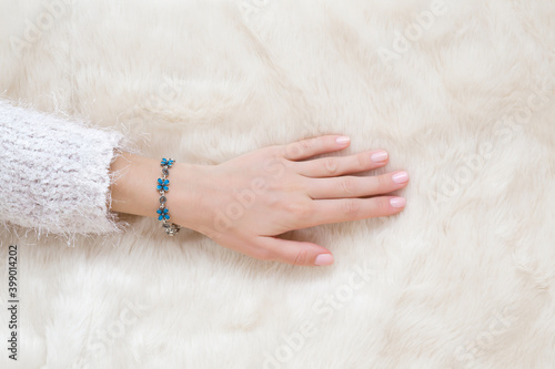 Canvas Print Young adult woman hand touching white fluffy fur blanket