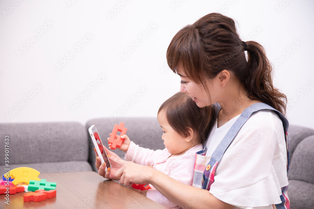 スマホをみる主婦と赤ちゃん
スマホをみる主婦と赤ちゃん