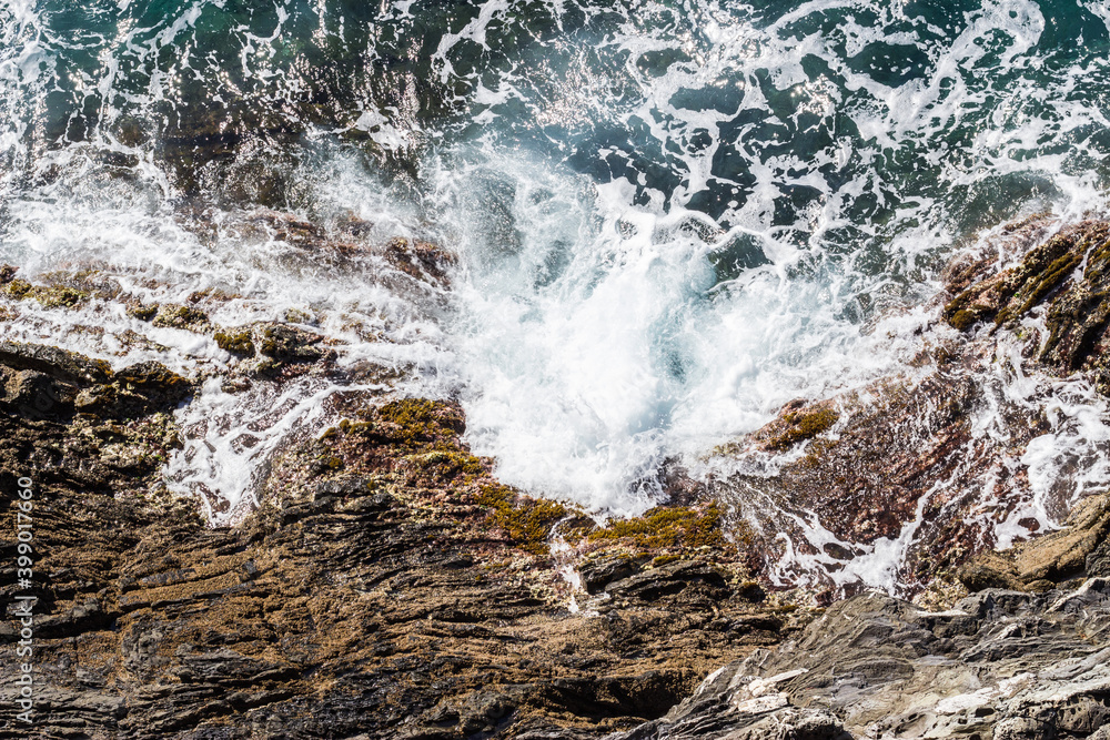 Obraz premium Water crashing on rocks aerial view. 