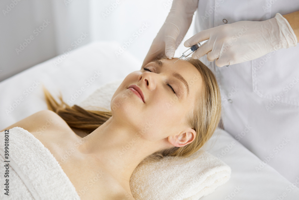 Beautician doctor doing beauty procedure with syringe to caucasian female face. Cosmetic medicine and surgery, beauty injections concept Beautician doctor doing beauty procedure with syringe to caucasian female face. Cosmetic medicine and surgery, beauty injections concept