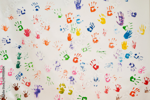 Background of many colorful hand prints on a wall. Childhood concept