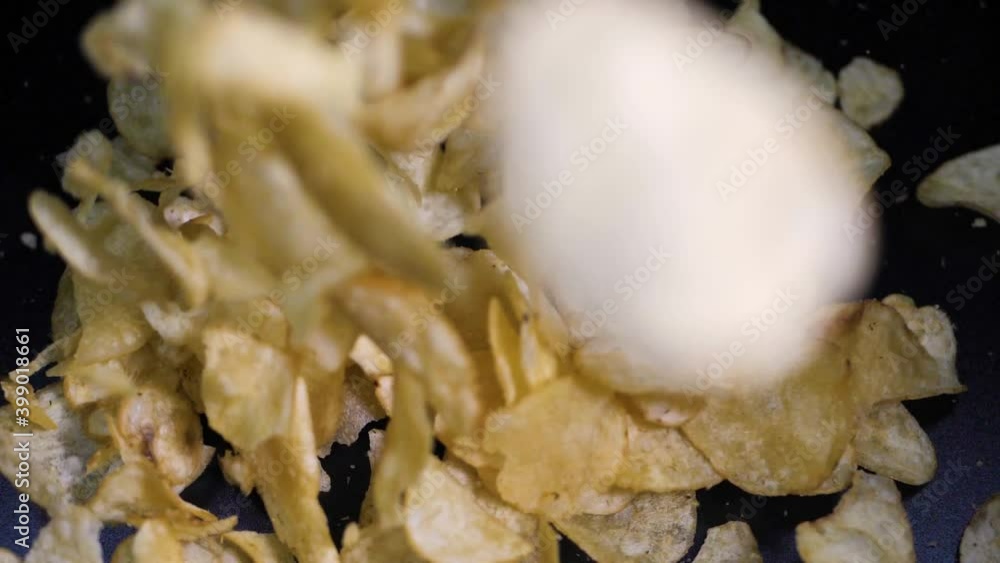 Potato chips fall on a black background, delicious, crunchy Potato chips fall on a black background, delicious, crunchy