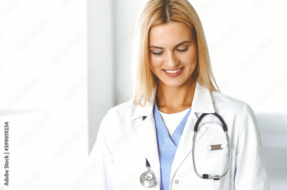 Woman-doctor at work in hospital is happy to communicate with female patient. Blonde physician checks medical history record and exam results. Medicine concept Woman-doctor at work in hospital is happy to communicate with female patient. Blonde physician checks medical history record and exam results. Medicine concept