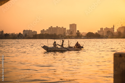 A family of local fishermen at sunset on the Nile river with the city of Cairo in the background. Africa