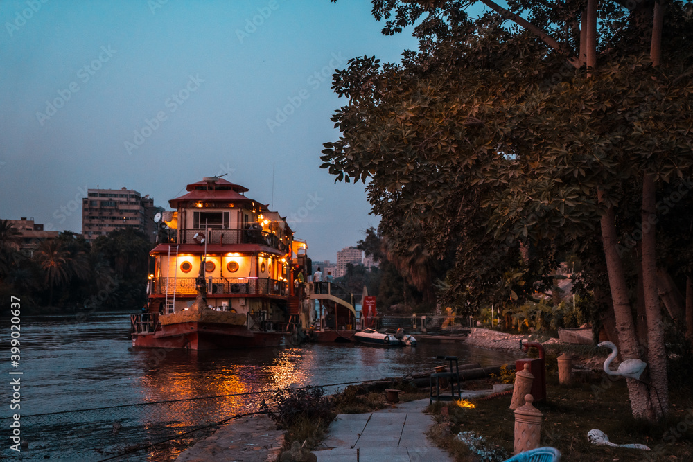 Obraz premium One cruise on the Nile river in the city of Cairo during the blue hour of sunset. Africa
