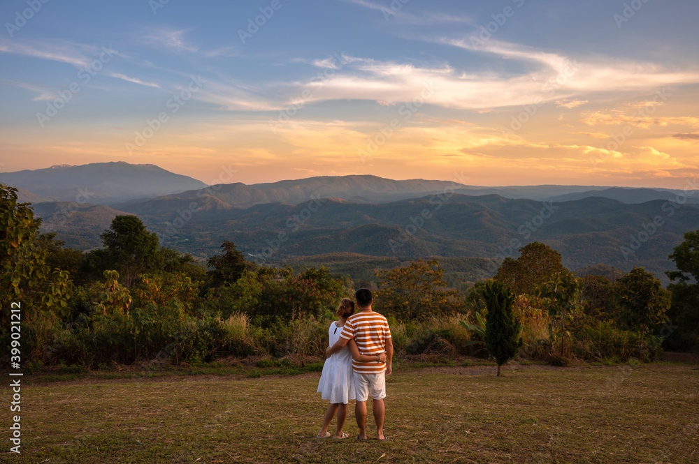 Happy couple hugging at sunset with amazing mountain view, Chiang Mai, Thailand.