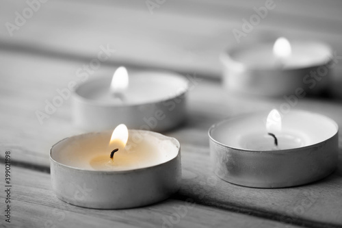 Burning candles on a wooden background, shot with shallow depth of field.