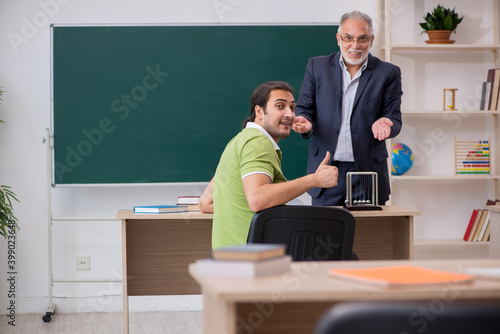 Aged physics teacher and male student in the classroom © Elnur