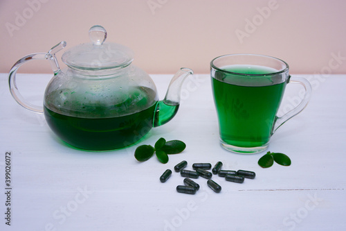 Teapot with a cup with chlorophyll tea, drink. Chlorella detox healthy drink in glass on a light background, Healthy drink. Superfood, natural antioxidant