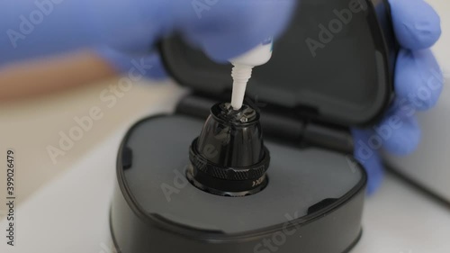 Ophthalmologist surgeon apply the gel to the surface Ophthalmoscopy Lens which is used in ophthalmic for the general diagnosis of eye diseases and specifically for Selective Laser Trabeculoplasty photo