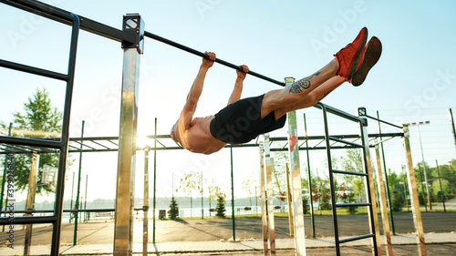 Strong man doing statics exercise on horizontal bar