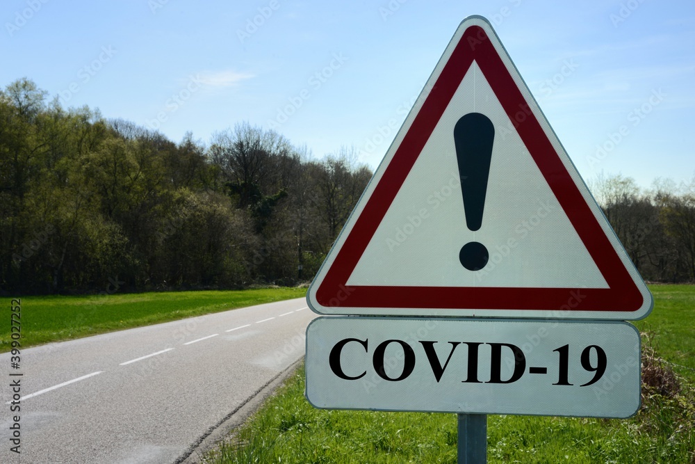 Concept de panneau indiquant danger covid-19 sur le bord d'une route de campagne