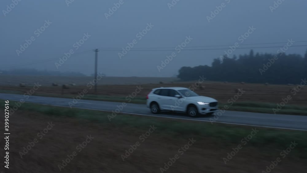 Expensive sport car SUV driving on the road highway at night in the forest Expensive sport car SUV driving on the road highway at night in the forest