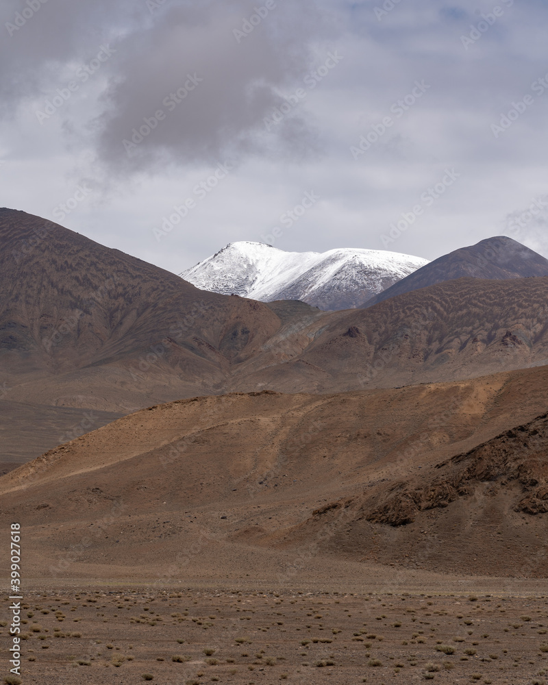 Beautiful muted colors of high-altitude mountains on the Pamir Highway near Ak Baital pass in Murghab district, Gorno-Badakhshan, Tajikistan on a gloomy overcast day Beautiful muted colors of high-altitude mountains on the Pamir Highway near Ak Baital pass in Murghab district, Gorno-Badakhshan, Tajikistan on a gloomy overcast day
