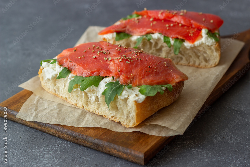 Open sandwiches with salmon, arugula and white cheese. Healthy eating. Open sandwiches with salmon, arugula and white cheese. Healthy eating.