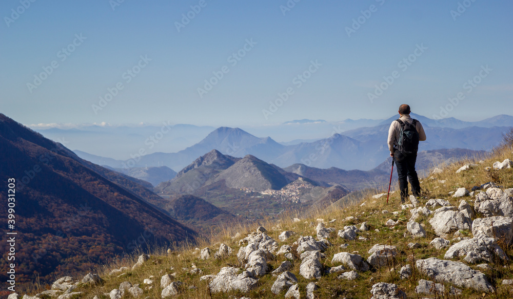 Fototapeta premium hiker on the top of a mountain in matese park and Letino in the background on Apennines in italy
