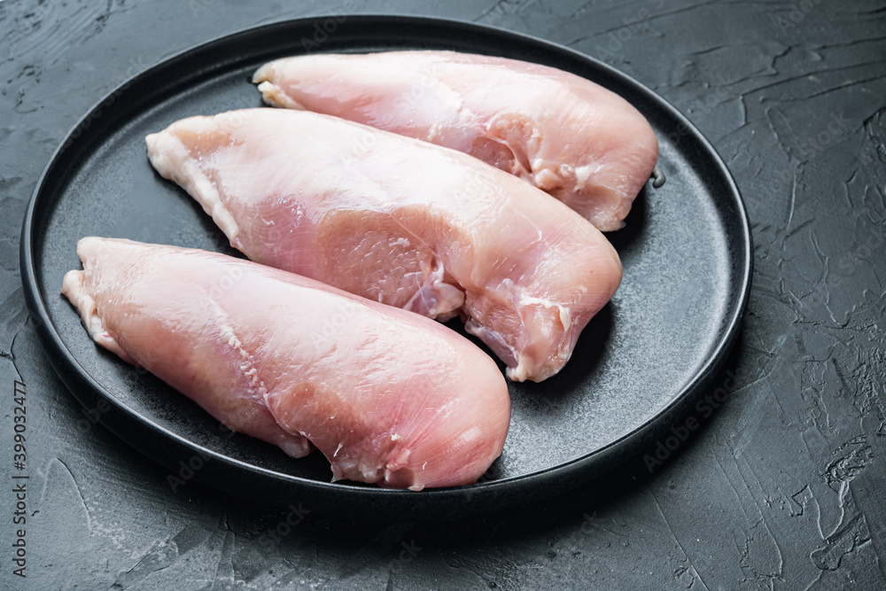 Chicken raw fillet, on black background with space for text