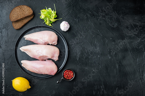 Raw crumbet chicken fillet with ingredients, on black background, flat lay  with copy space