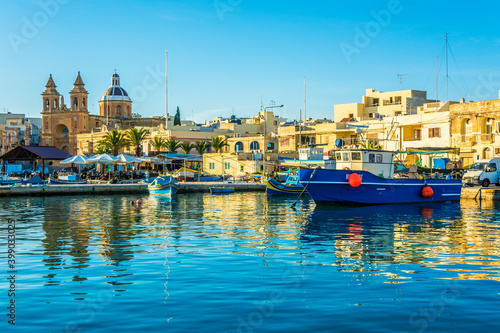 Colorful painted wood boats with the typical protective eyes on a sunny day in Marsaxlokk, Malta.