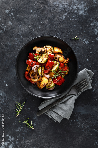 Grilled vegetables with mushrooms in a plate on a dark background
