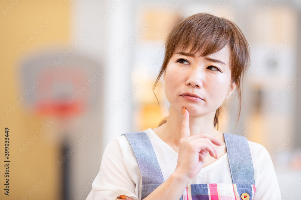 考えるエプロン姿の女性 Stock Photo Adobe Stock