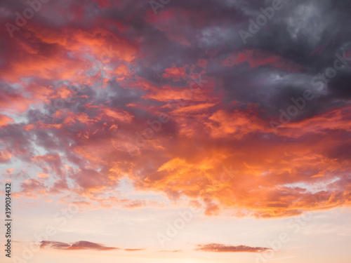Gorgeous sunset with clouds of different shapes. Evening sky with orange, red and violet fluffy clouds. Colorful cloudscape.
