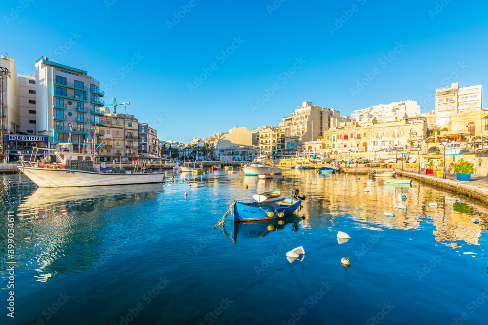 Small fishing boats moored in St Julians and Spinola bay on a sunny day in St Julians, Malta. St Julians is populer tourist destination in Malta.
