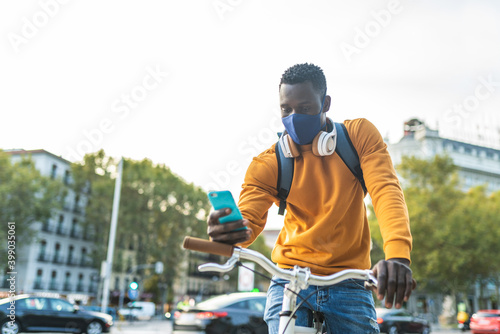 Black Man Using Cellphone Wearing Face Mask Outdoors.