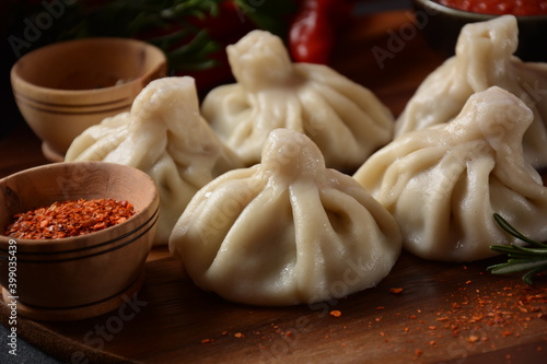 Georgian dumplings Khinkali with meat and red pepper, Traditional National Georgian cuisine. Khinkali with local sauces - tkemali, satsebeli, adzhika.