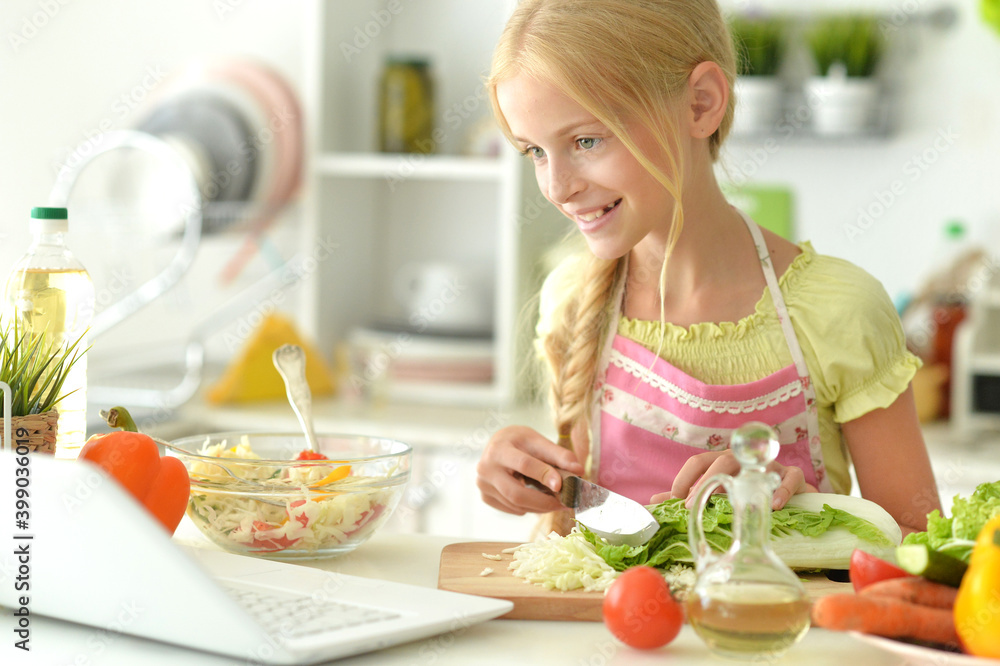 Girl preparing delicious fresh salad in kitchen