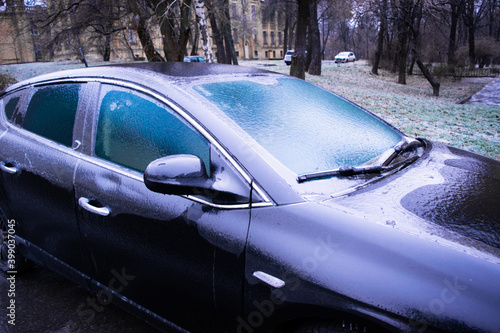The parked car is covered with a crust of transparent ice. Winter weather surprises. © jana_janina