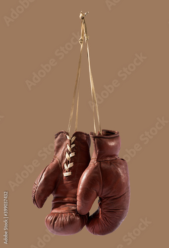 Boxing gloves hanging against brown background