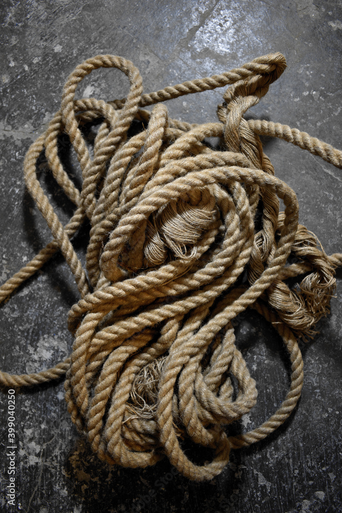 A coil of jute rope on a concrete background