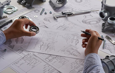 Engineer technician designing drawings mechanical parts engineering Engine.manufacturing factory Industry Industrial work project blueprints measuring bearings caliper tools