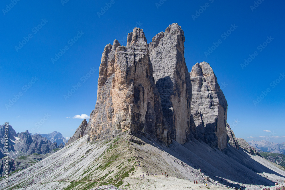 Panoramic view of  of Tre Cime di Lavaredo mountain peaks Drei Zinnen in the Dolomites Italian Alps with blue sky in background