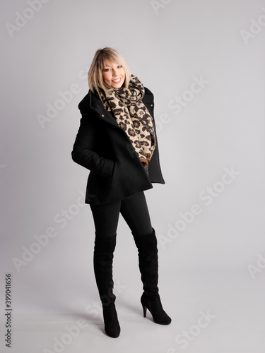 Pretty young woman poses with cheerful and friendly winter and fitness clothes
